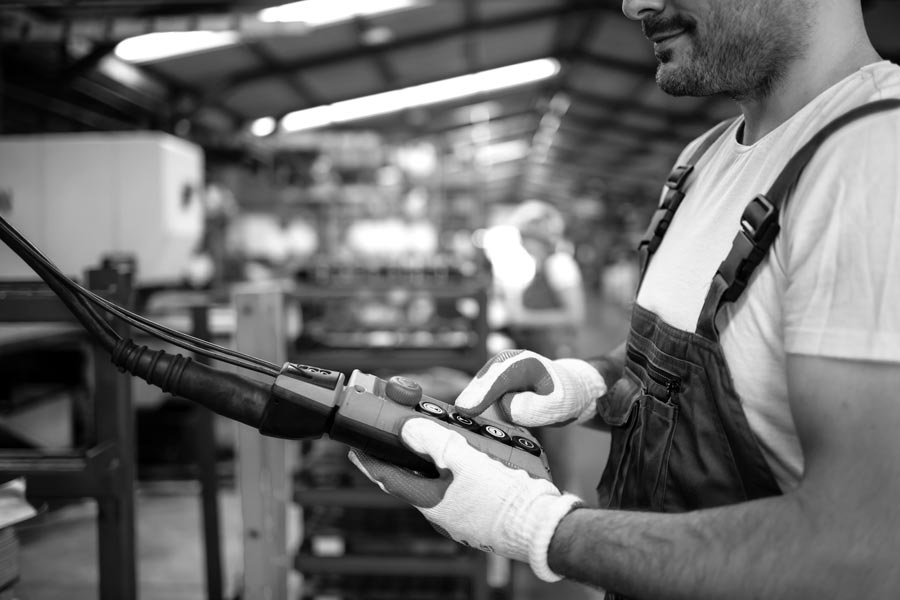 factory-worker-wearing-uniform-hardhat-operating-industrial-machine-with-push-button-joystick-production-hall